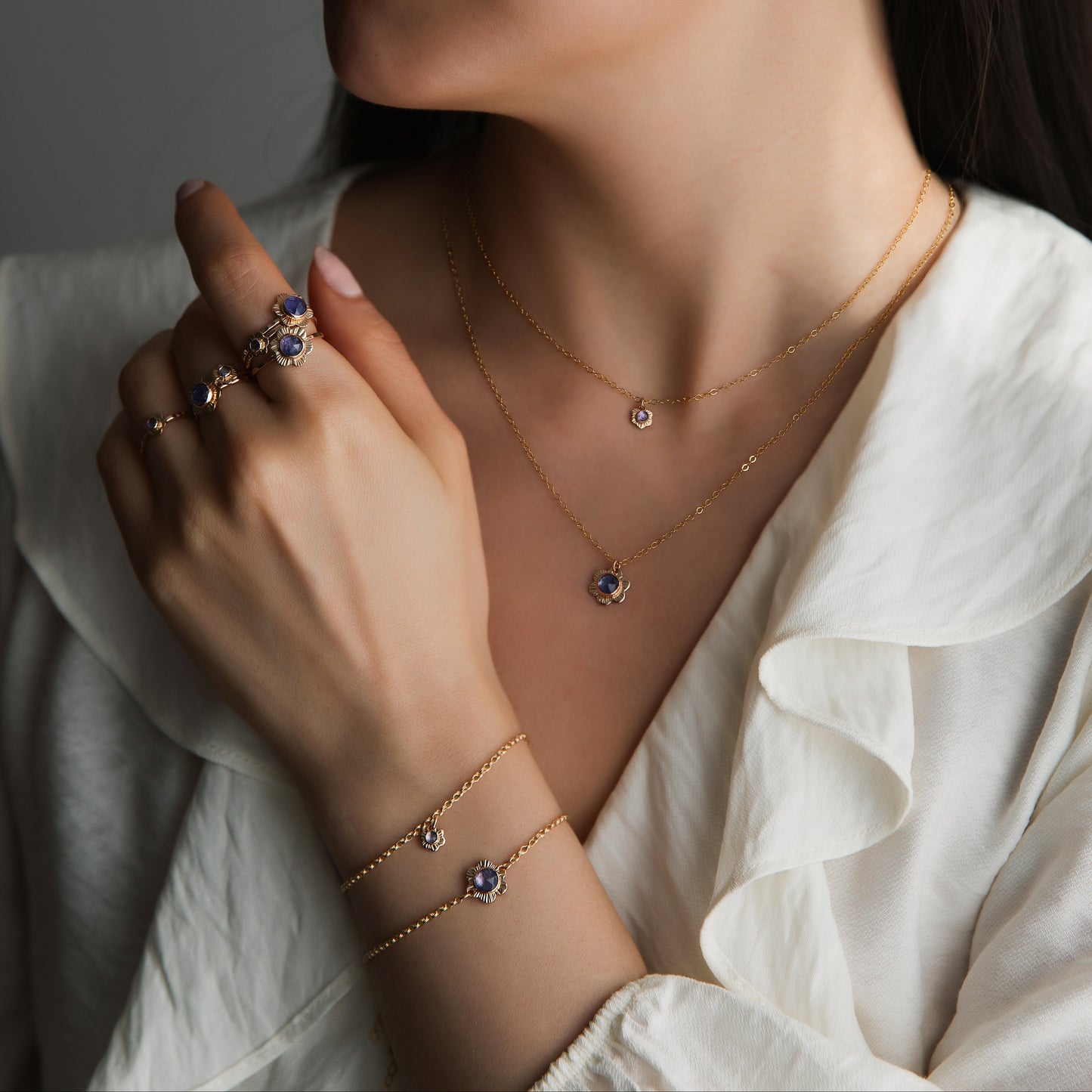 woman wearing gold flower rings, necklaces and bracelets