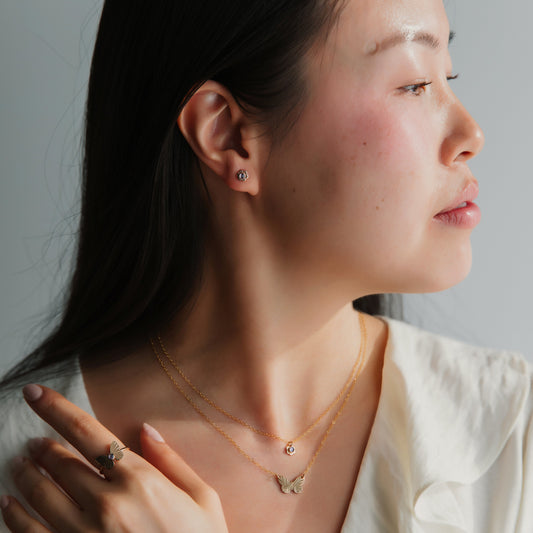 A person wearing mini flower stud earrings