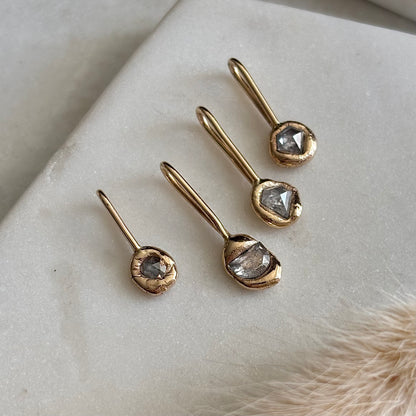 Gold rose cut natural diamond pendants on a light surface