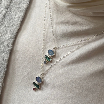 Necklace with gemstone pendants on a soft fabric background