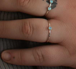Close-up of a hand wearing a silver ring with small stones.