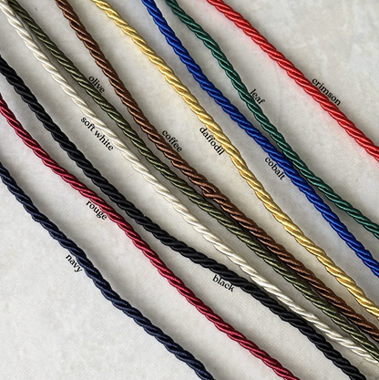 Set of colored wires arranged in a row on a textured white background with color labels.