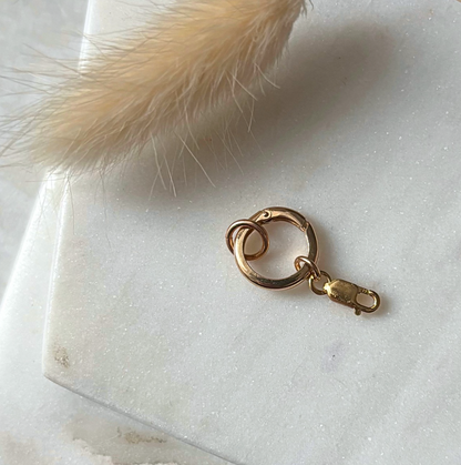 Gold round charm lock on a marble surface 