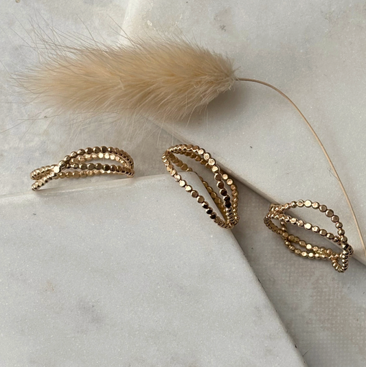 Gold rings on a marble surface with a feather