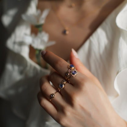 A woman's hand featuring gold flower rings.