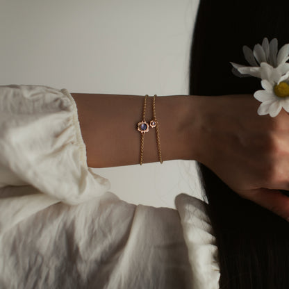 woman with her hand in her hair wearing gold flower rings and bracelets