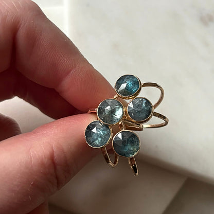 Kyanite rings held between two fingers.
