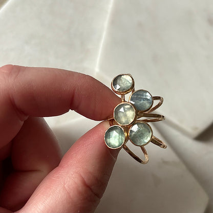 Gold kyanite rings displayed on a marble surface.