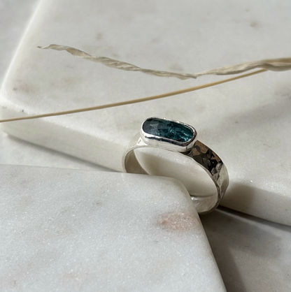 silver ring with a blue gemstone on a marble background