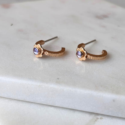 Small gold hoop earrings with tiny flowers on them