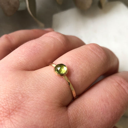 A single Peridot stacking ring with a gold-fill band, worn on a finger.