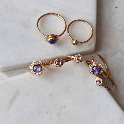 Gold flower rings on a marble background.