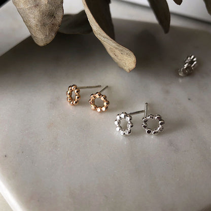Small gold-fill and silver circle earrings with a textured surface.