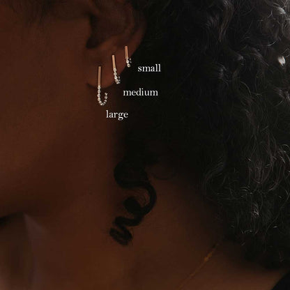 A set of three J-hoop earrings made of sterling silver with hand-textured orbs.