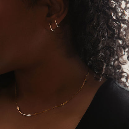 A set of two J-hoop earrings made of sterling silver with hand-textured orbs.