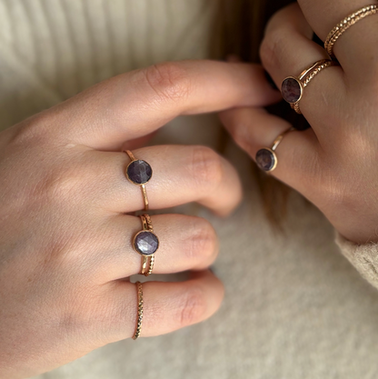 A person's hands showing sapphire rings in gold.