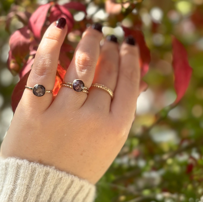 A person's hands showing sapphire rings in gold.