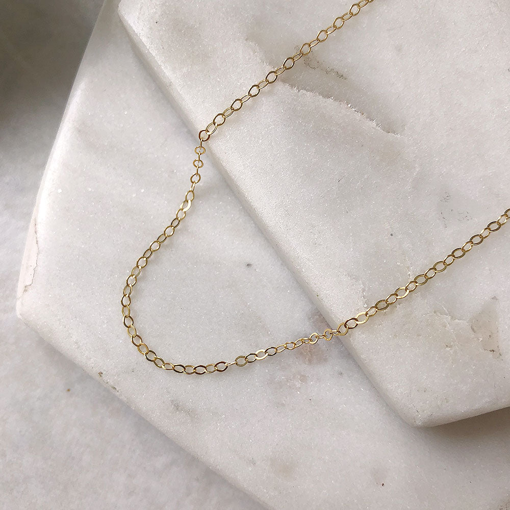strut jewelry standard cable chain necklace 14k gold fill on a marble background
